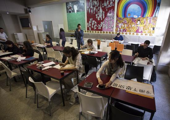 People take part in the Chinese calligraphy competition organized by the Confucius Institute of the University of Buenos Aires, at the University Language Center, as part of the celebration of the 10th anniversary of Confucius Institutes in the city of Buenos Aires, capital of Argentina, on Sept. 27, 2014. (Xinhua/Martin Zabala)