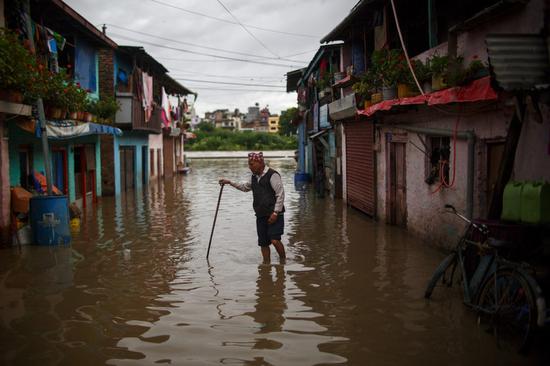 A man makes his way through flood water in Kathmandu, Nepal on July 20, 2020. (Photo by Sulav Shrestha/Xinhua)