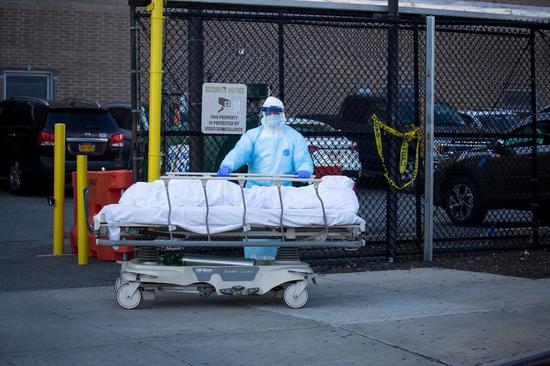 A medical worker transfers the body of a victim who died of COVID-19 at a hospital in New York, the United States, April 6, 2020. (Photo by Michael Nagle/Xinhua)