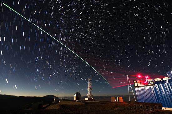 Composite photo taken on Dec 9, 2016 shows a satellite-to-earth link established between quantum satellite "Micius" and the quantum teleportation experiment platform in Ali, Southwest China's Tibet autonomous region. [Photo/Xinhua]