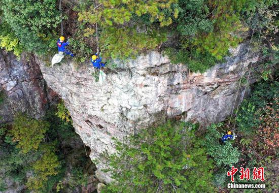 Blue Sky rescue team clean garbage on cliff in Zhangjiajie
