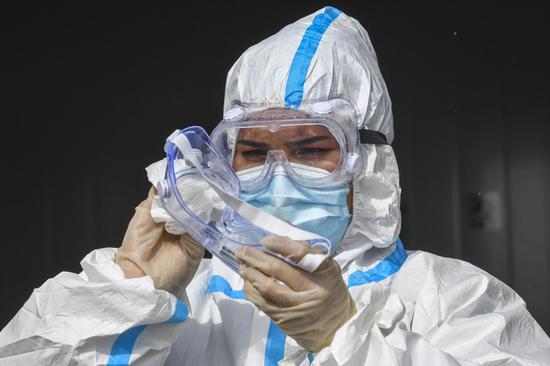 An epidemic prevention staff member processes a protective goggle at Karasu port of northwest China's Xinjiang Uygur Autonomous Region, Oct. 16, 2020. (Xinhua/Zhao Ge)