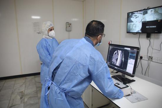 Dr. Mohammed Abdul-Hussein (R) and CT technician Hanan Jamal examine lung images in a Chinese-built CT room at al-Shifaa Center in Baghdad, Iraq, Oct. 12, 2020.(Xinhua)
