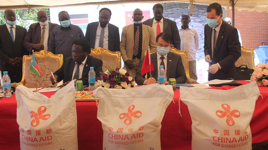 Manasseh Lomole (L, Front), chairperson of South Sudan's Relief and Rehabilitation Commission, and Chinese ambassador to South Sudan Hua Ning (R, Front) sign documents during a handover ceremony of food aid in Juba, South Sudan, September 17, 2020. (Photo/Xinhua)
