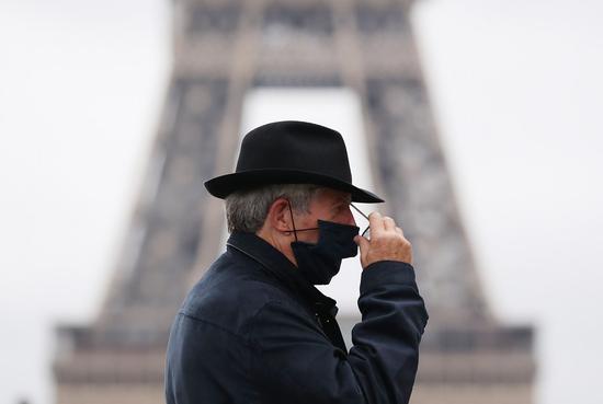A man wearing a face mask walks past the Trocadero Place near the Eiffel Tower in Paris, France, Oct. 23, 2020. (Xinhua/Gao Jing)