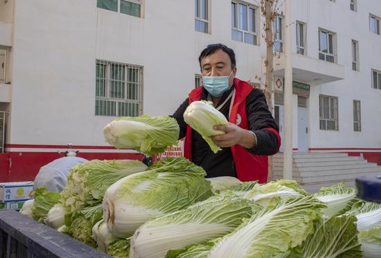 A volunteer prepares to deliver vegetable to a community in Tokzak Township, Shufu County of Kashgar Prefecture, northwest China's Xinjiang Uygur Autonomous Region, Oct. 26, 2020. (Xinhua/Hu Huhu)