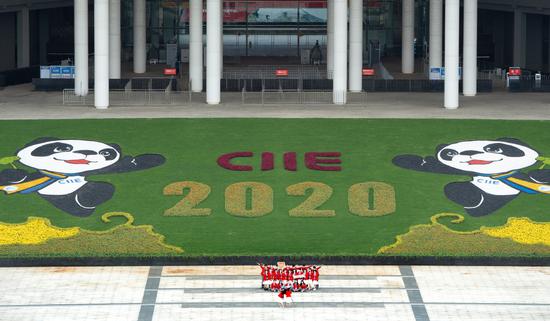 An aerial view shows volunteers posing amid the decorations at the National Exhibition and Convention Center in Shanghai, the venue for the 3rd CIIE. (Photo by GAO ERQIANG/CHINA DAILY)