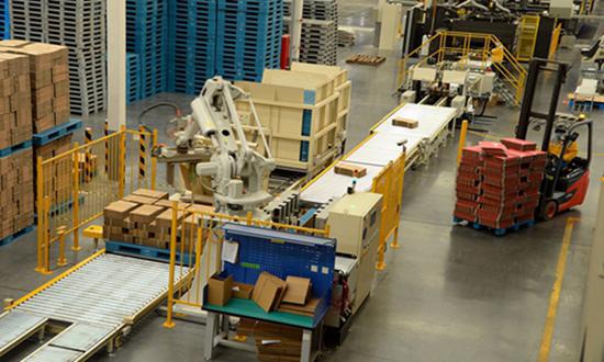 A robot arm helps pack components in a traditional manufacturing facility in Taicang, East China's Jiangsu Province. (Photo/China News Service)