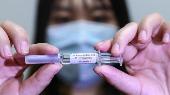 A staff member displays a sample of the COVID-19 inactivated vaccine at a vaccine production plant of China National Pharmaceutical Group Co., Ltd. (Sinopharm) in Beijing, April 10, 2020. /Xinhua

