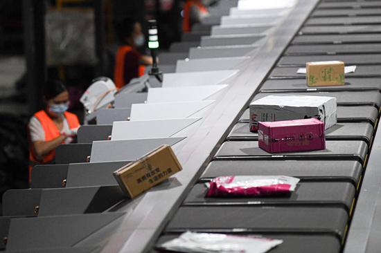 Employees work at an express distribution center of the delivery company SF Express in Haikou, south China's Hainan Province, Nov. 8, 2020.