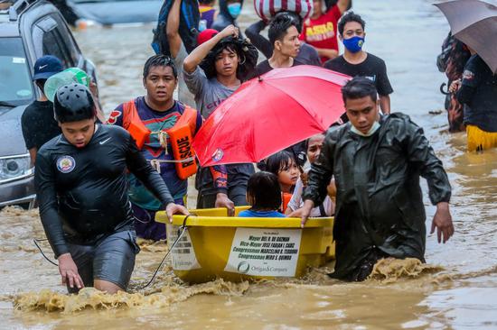 Rescuers of the Philippine National Police (PNP) evacuate residents from the flood brought by typhoon Vamco in Manila, the Philippines, on Nov. 12, 2020. (Xinhua/Rouelle Umali)