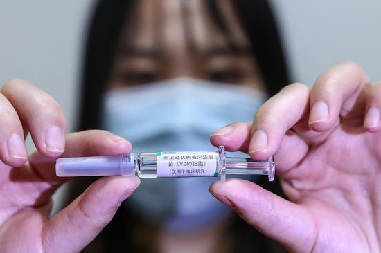 A staff member displays a sample of the COVID-19 inactivated vaccine at a vaccine production plant of China National Pharmaceutical Group Co., Ltd. (Sinopharm) in Beijing, capital of China, April 10, 2020. (Xinhua/Zhang Yuwei)