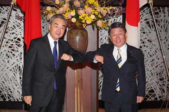 Chinese State Councilor and Foreign Minister Wang Yi (L) touches his elbow with Japanese Foreign Minister Toshimitsu Motegi before their meeting in Tokyo, Japan, Nov. 24, 2020. (Xinhua/Du Xiaoyi)