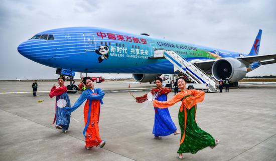 Dancers wearing Tang Dynasty (618-907) costumes stage a traditional performance near a China Eastern Airlines' aircraft during a celebration at Xi'an Xianyang International Airport in Shaanxi province in October. (Photo by Wang Jian/For China Daily)