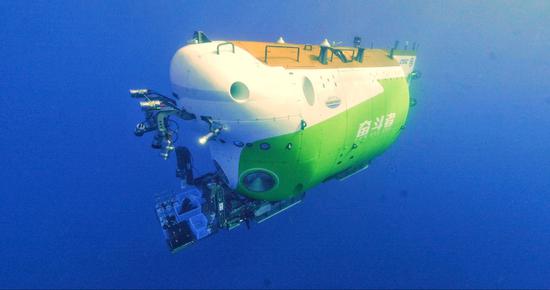 The crew of the scientific research ship Tansuo-1, celebrates on Saturday after China's new deep-sea manned submersible Fendouzhe, or Striver, completed its ocean expedition and returned to a port in Sanya, Hainan province. The submersible set a national record by diving to a depth of 10,909 meters in the Mariana Trench during the expedition.(Photo/China Daily)