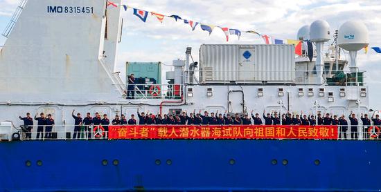 The crew of the scientific research ship Tansuo-1, celebrates on Saturday after China's new deep-sea manned submersible Fendouzhe, or Striver, completed its ocean expedition and returned to a port in Sanya, Hainan province. The submersible set a national record by diving to a depth of 10,909 meters in the Mariana Trench during the expedition. (Photo/China Daily)