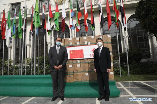 Chinese Ambassador to Egypt Liao Liqiang (R) and Assistant Secretary-General of the Arab League Hossam Zaki pose for a photo during the medical aid delivery ceremony at the headquarters of Arab League in Cairo, Egypt, on Dec. 8, 2020. China on Tuesday delivered the second batch of anti-coronavirus medical aid, including 130,000 N95 masks, to the Arab League based in Cairo, capital of Egypt. (Xinhua/Ahmed Gomaa)