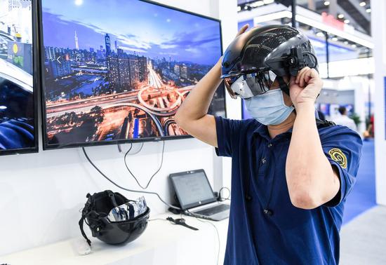 A staff member demonstrates a thermal imaging smart helmet for detection of febrile people during the 22nd China Hi-Tech Fair (CHTF) in Shenzhen, south China, Nov. 11, 2020. (Xinhua/Mao Siqian)