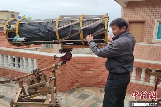 Astronomy fan Yan Mingzhe shows his self-made Newtonian telescope. (Photo provided to China News Service)