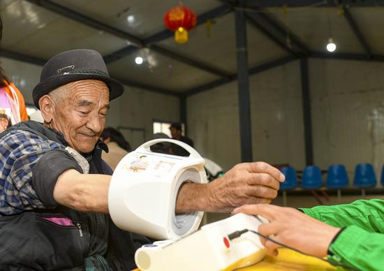 A villager has his blood pressure measured at the clinic of Yaragzi Village in Xihxu Township in Yecheng County, northwest China's Xinjiang Uygur Autonomous Region, May 2, 2020. (Xinhua/Hu Huhu)