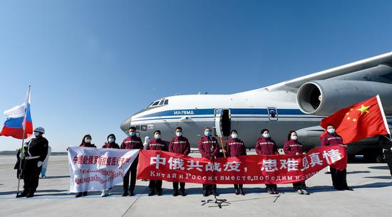 Chinese medical experts pose for a photo before boarding a plane to Russia at an airport in Harbin, northeast China's Heilongjiang Province, April 11, 2020. (Photo by Xu Xu/Xinhua)