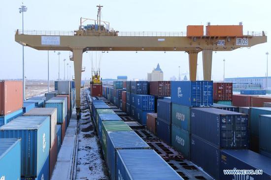 Photo taken on Jan. 5, 2021 shows a gantry crane lifting a container in Manzhouli, north China's Inner Mongolia Autonomous Region. The number of China-Europe freight trains arriving and departing via Manzhouli, China's largest land port, reached a record high in 2020 despite the impact of COVID-19, local railway authorities said Wednesday. (Photo by Guo Nailun/Xinhua)