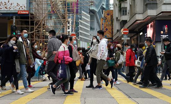 People wearing face masks walk on a street in south China's Hong Kong, Jan. 10, 2021. (Xinhua/Li Gang)