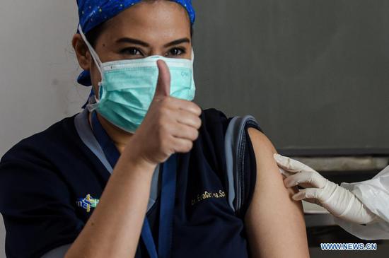 A health worker thumbs up after receiving a dose of China's Sinovac COVID-19 vaccine at Siloam Hospital in Jakarta, Indonesia. Jan. 14, 2021. Indonesia begins its large scale vaccination on Thursday. (Xinhua/Agung Kuncahya B.)