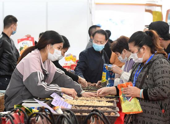 Visitors select products during the 17th China-ASEAN Expo at Nanning International Convention and Exhibition Center in Nanning, south China's Guangxi Zhuang Autonomous Region, Nov. 30, 2020. (Xinhua/Lu Boan)