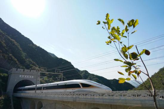 A Fuxing high-speed train runs through the Juyongguan Tunnel on the Beijing-Zhangjiakou high-speed rail line. (Xinhua/Ju Huanzong)
