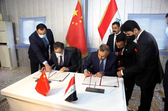 Chinese Ambassador to Iraq Zhang Tao(L) and Iraqi Interior Ministry's Senior Deputy Minister Hussein al-Awadi(R) sign the handover of Chinese donation in Baghdad, Iraq on Jan. 21, 2021.(Xinhua)