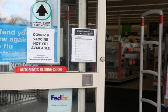 A notice telling COVID-19 vaccine is not yet available is pictured on the door of a pharmacy in New Orleans, Louisiana, the United States, Nov. 25, 2020. (Photo by Lan Wei/Xinhua)