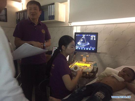 File photo shows Chinese medical staff making cardiology examination for a Cambodian child in Phnom Penh, Cambodia, in 2019. The ongoing China-Cambodia Love Heart Journey project has not only saved the lives of dozens of Cambodian children with congenital heart disease (CHD), but also bridged hearts of peoples of the two countries. Launched in January 2018, the China-aided project aimed to provide 150 Cambodian children who have CHD with free surgery or treatment at the Fuwai Yunnan Cardiovascular Hospital in Southwest China's Yunnan Province. (Photo by Chea Monyrith/Xinhua)