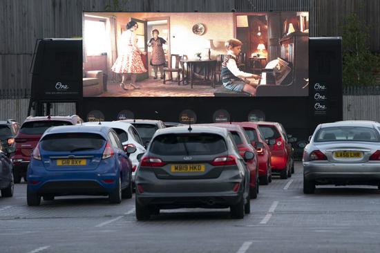People sit in cars watching a film at a drive-in cinema amid the COVID-19 pandemic in Manchester, Britain on June 27, 2020. (Photo by Jon Super/Xinhua)