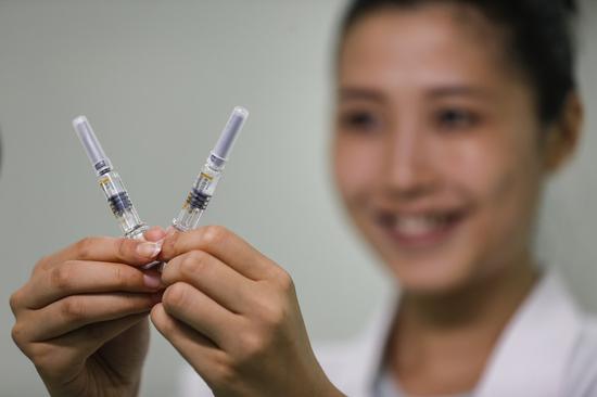 A staff member of Sinovac Biotech, a Chinese biopharmaceutical company, displays two doses of COVID-19 inactivated vaccine in prefilled syringes in Beijing, capital of China, Dec. 23, 2020. (Xinhua/Zhang Yuwei)