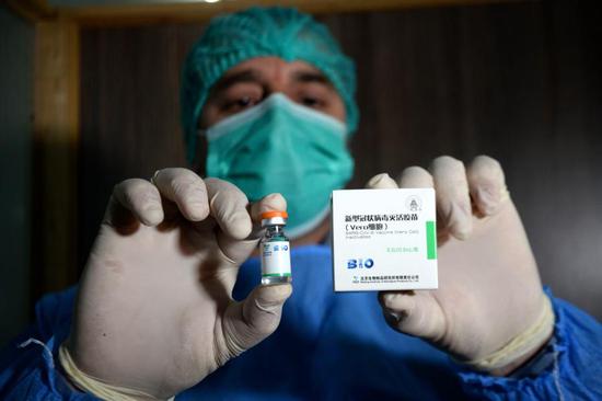 A medical worker shows China's COVID-19 vaccine at a hospital in Peshawar, Pakistan, Feb. 3, 2021. (Photo by Umar Qayyum/Xinhua)