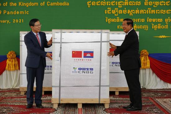 Chinese Ambassador to Cambodia Wang Wentian (L) hands over the China-donated Sinopharm COVID-19 vaccines to Cambodian Prime Minister Samdech Techo Hun Sen on Feb. 7, 2021. (Photo by Sovannara/Xinhua)