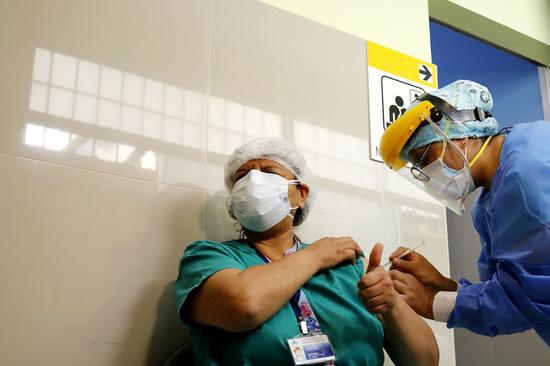 A health worker receives a vaccine from the Chinese company Sinopharm against the novel coronavirus disease (COVID-19), at the San Bartolome National Hospital, in Lima, Peru, on February 9, 2021.(Xinhua/Mariana Bazo)