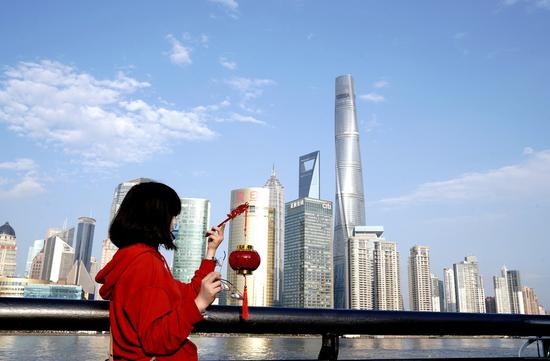 A tourist visits the Bund during the Lunar New Year holiday in east China's Shanghai, Feb. 14, 2021. (Xinhua/Zhang Jiansong)