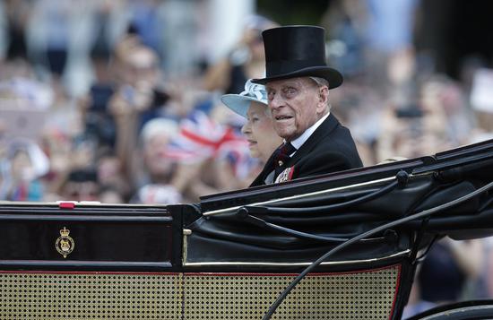 Queen Elizabeth II and Prince Philip travel in a horse-drawn carriage back to Buckingham Palace after attending Trooping the Colour in London, Britain on June 17, 2017. (Xinhua File/Han Yan)