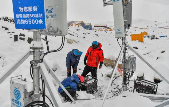 Staff members of China Mobile test the signals of the 5G base station built at an altitude of 6,500 meters at the advance camp of Mount Qomolangma in southwest China's Tibet Autonomous Region on May 21, 2020. (Xinhua/Jigme Dorje)