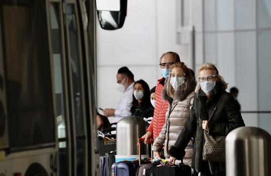 Travelers with face masks wait for public transportation services at the International Airport in Los Angeles, California, the United States, on Feb. 1, 2021. (Xinhua)