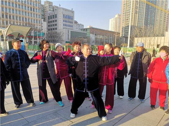Long Jing (second from right) instructs enthusiasts during her daily morning exercise session at the Dongfanghong square in Lanzhou, Gansu province, on Friday. (Photo by Zhang Junwei/For China Daily)