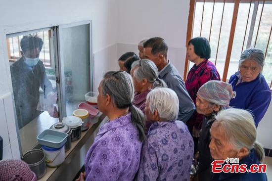 Elderly people receive free lunch from village canteen