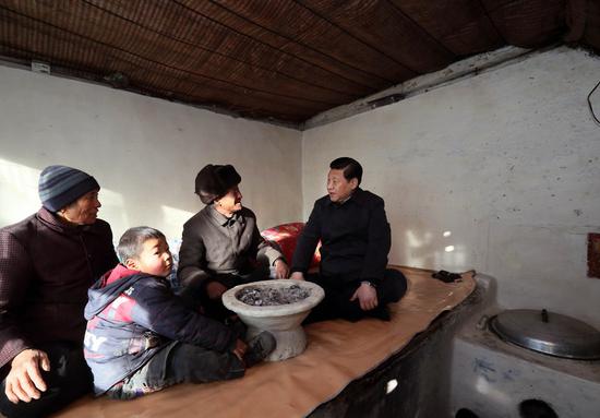 Xi Jinping (R), general secretary of the Communist Party of China (CPC) Central Committee and chairman of the CPC Central Military Commission, visits the family of Tang Rongbin, an impoverished villager in the Luotuowan Village of Longquanguan Township, Fuping County, North China's Hebei province. Xi made a tour to impoverished villages in Fuping County from Dec 29 to 30, 2012.(Photo/Xinhua)