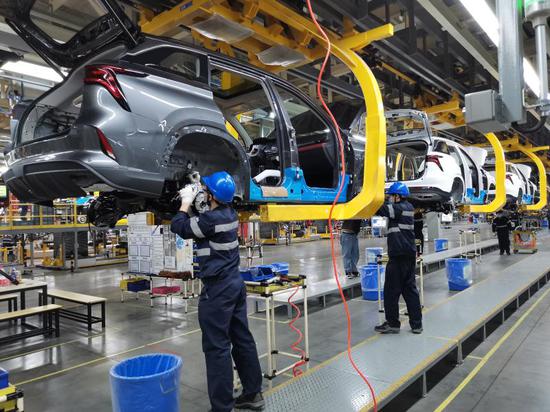 Photo taken with a mobile phone shows employees working on the production line at Hefei Changan Automobile Co., Ltd. in Hefei, east China's Anhui Province, Feb. 17, 2021. (Xinhua/Liu Fangqiang)