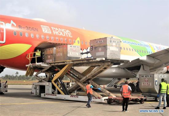 Workers unload the COVID-19 vaccine donated by China at an airport in Freetown, Sierra Leone, on Feb. 25, 2021. Sierra Leone on Thursday received a consignment of 200,000 doses of China's Sinopharm COVID-19 vaccine donated by China to support the country's vaccination campaign. (Photo by Abu/Xinhua)