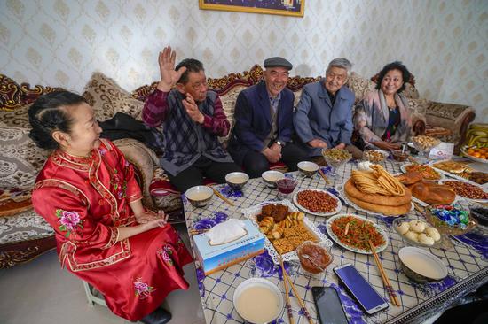 Emin (2nd L), a resident of Uygur ethnic group, chats with his neighbors in Tacheng City, northwest China's Xinjiang Uygur Autonomous Region, April 2, 2020. (Xinhua/Zhao Ge)