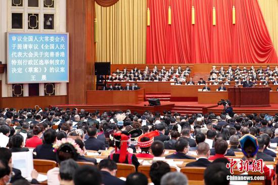 A draft decision on improving the electoral system of the Hong Kong Special Administrative Region was submitted to the 4th annual session of the 13th National People's Congress (NPC) for deliberation on March 5, 2021. (Photo/China News Service)