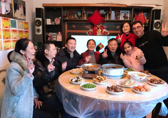 Ghamgeen Izat Rashed, right, an Iraqi university teacher in Wuhan, poses with his wife's family at a Spring Festival family gathering in the city. (Photo provided to China Daily)